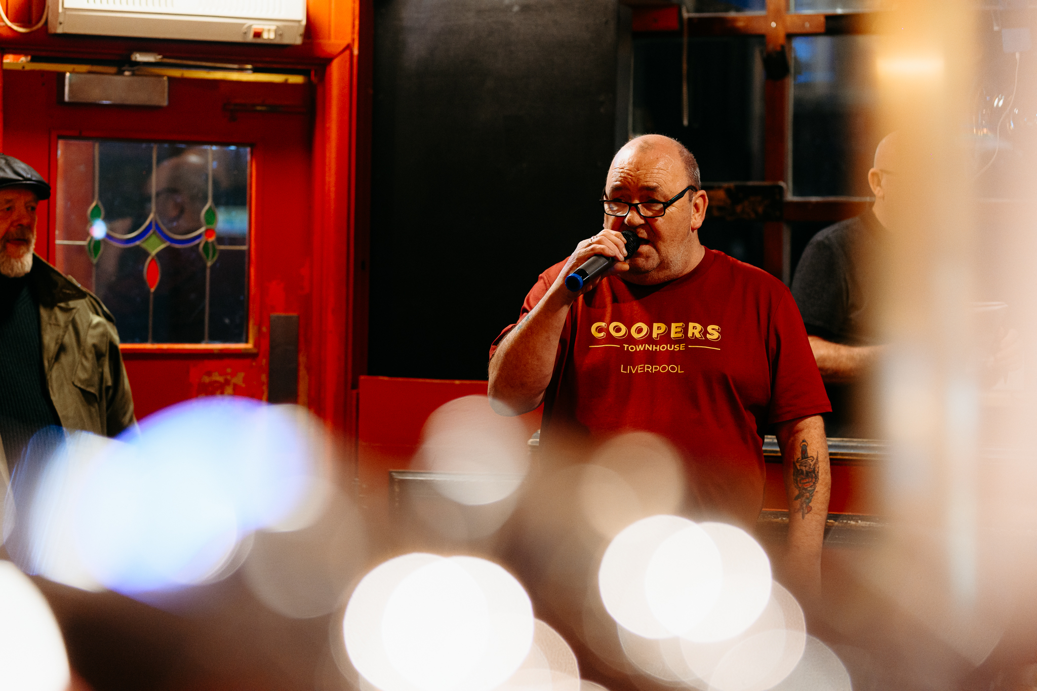 DJ holding microphone wearing Coopers t-shirt